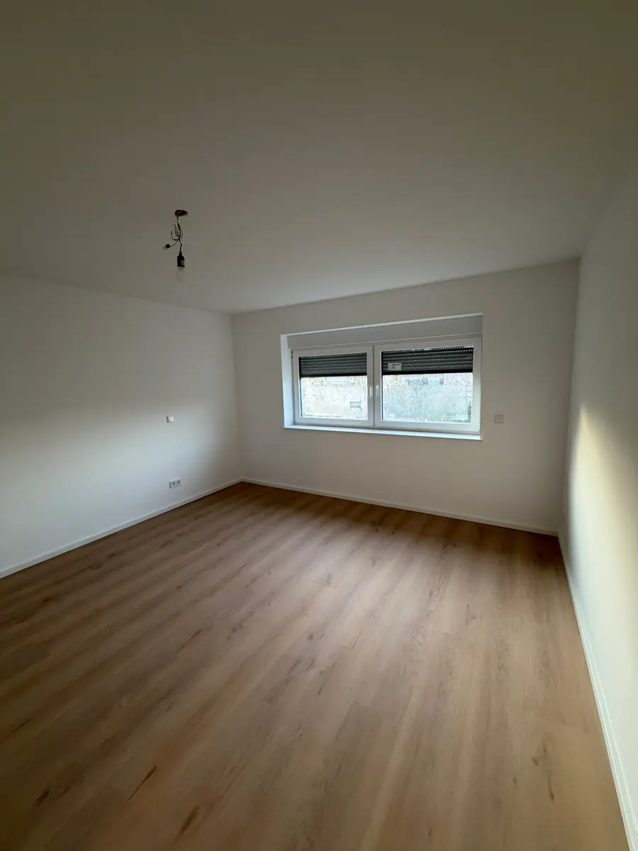 Fertig saniertes Zimmer mit Holzboden und neuem Fenster